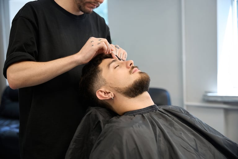 Barber applying wax for eyebrow grooming