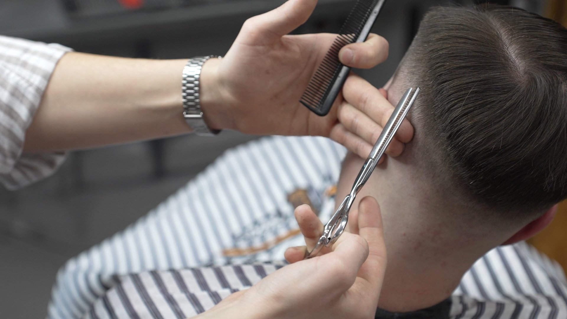 Professional barber trimming client's hair
