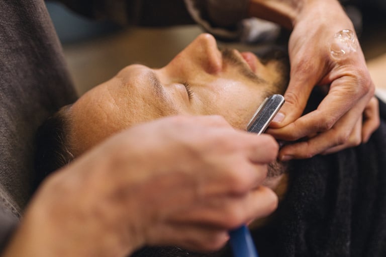 Barber shaving male neck with straight razor